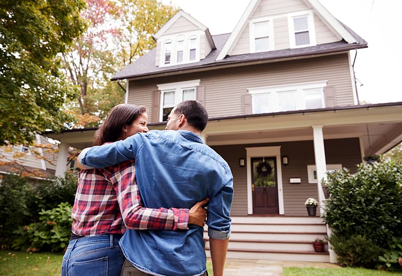 Couple in front of house.